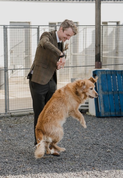 Groom and dog play together