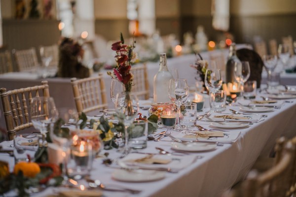 Empty dining room ballroom flowers candles and glasses on table