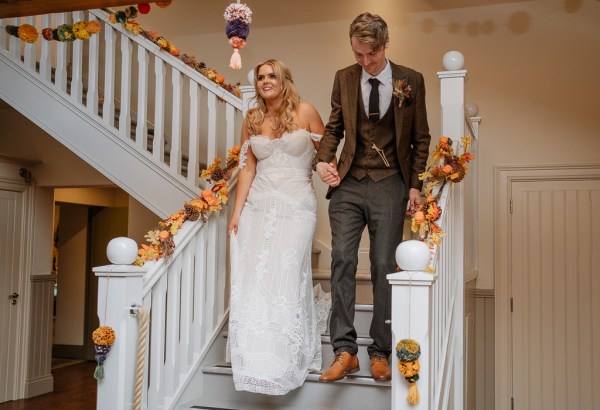 Bride and groom walk down the staircase