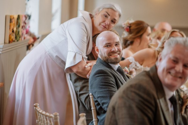 Guests in audience look at groom give speech