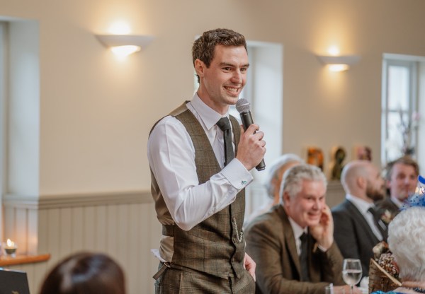 Groom giving speech into microphone