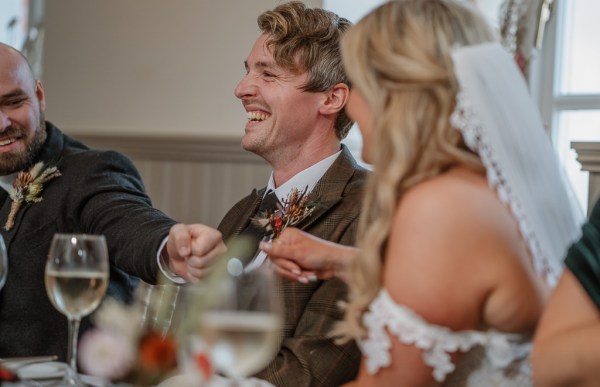 Bride and groom laughing at the table