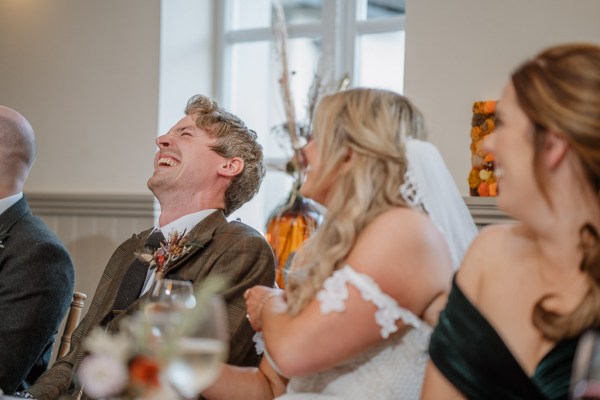 Bride and groom laugh at the table