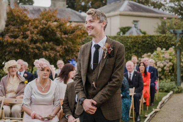 Groom waits with guests for the bride