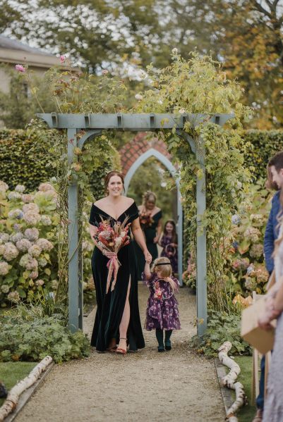 Bridesmaid and little girl walk down the aisle together