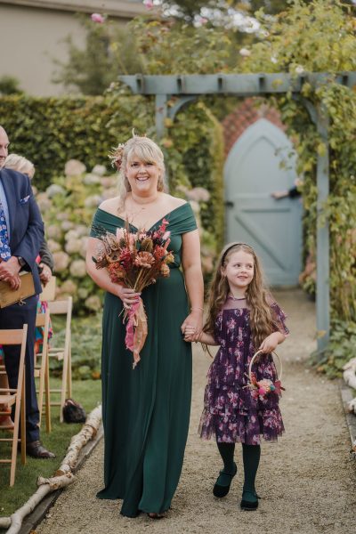 Bridesmaid and little girl walk down the aisle together