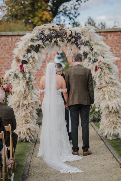 Bride and groom before priest smile