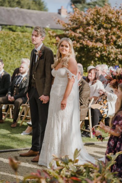 Bride groom at alter in front of guests