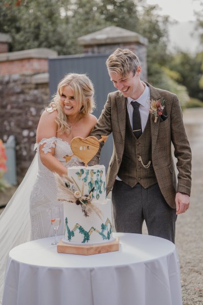 Bride and groom cut the wedding cake together