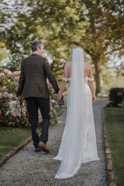 Bridal gown dress detail long train lace from behind and groom