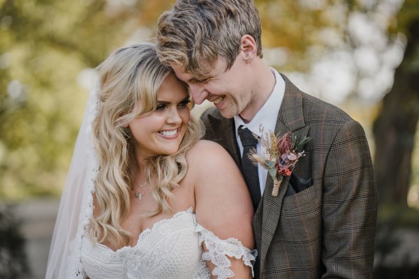 Bride and groom smiling at each other in garden forest setting