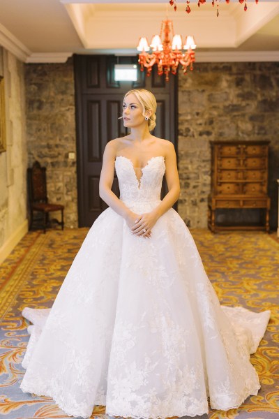 Bride poses for the camera in bedroom