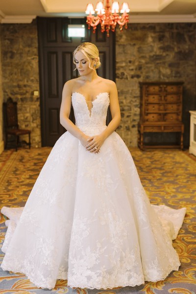 Bride poses for the camera in bedroom