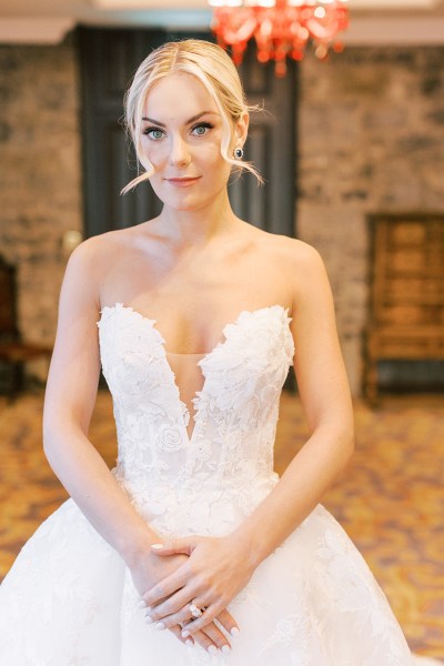 Bride poses for the camera in bedroom