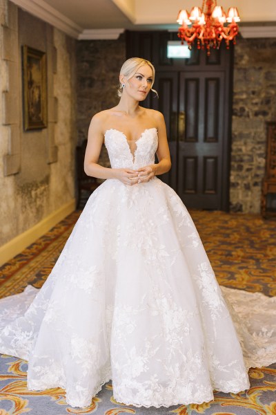 Bride on her own standing in bedroom