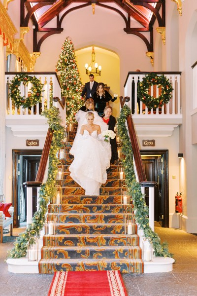 Bride and family members help her walk down the staircase stairs