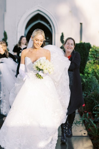 Bride gets help with her dress walking