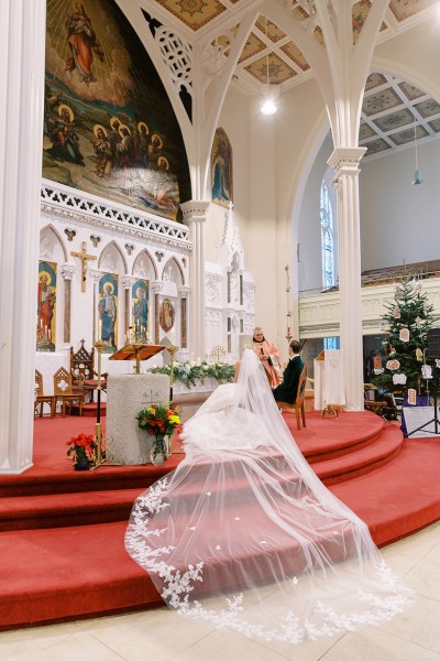 Long train on red steps bride groom at alter