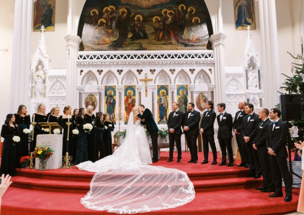 Long train of bridal gown/dress on steps with groom and groomsmen/bridesmaids