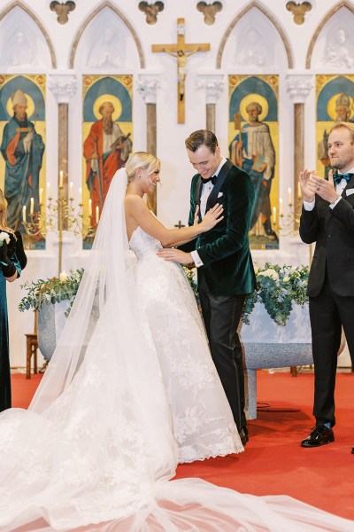 Bride and groom at alter smiling guests clapping