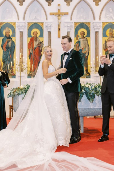 Bride and groom at alter smiling guests clapping