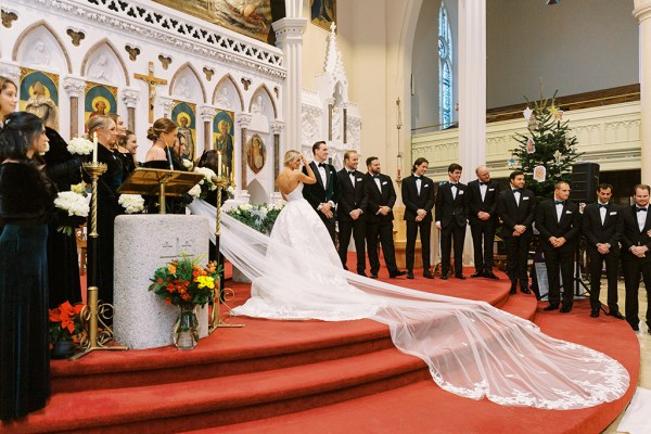 Long train of bridal gown/dress on steps with groom and groomsmen/bridesmaids