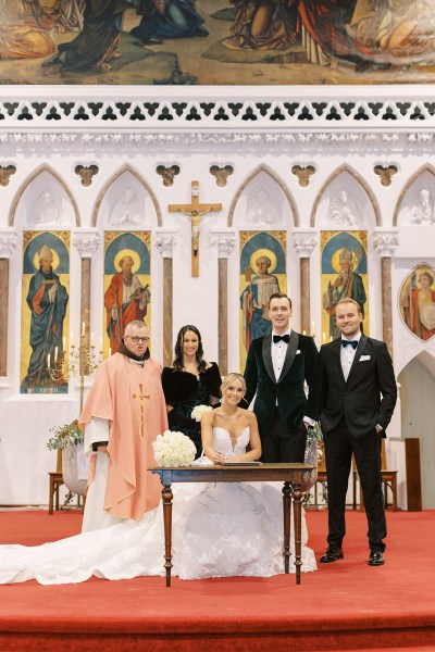 Groom and groomsman at alter with priest