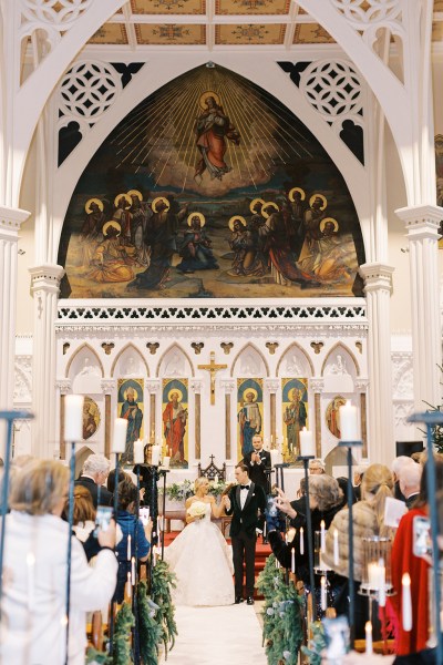 Bride and groom hand in the air exiting church