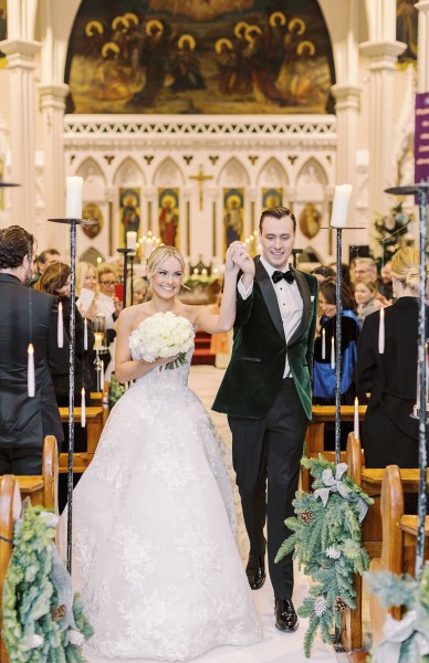 Bride and groom hand in hand walking down the aisle