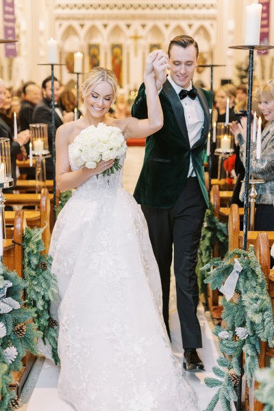 Bride and groom hand in the air exiting church