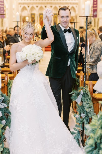 Bride and groom hand in the air exiting church