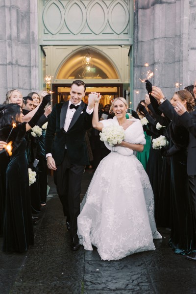 Bride and groom exit church guests clap