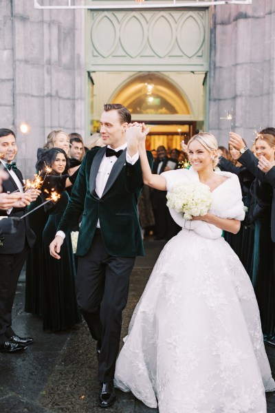 Bride and groom exit church guests clap