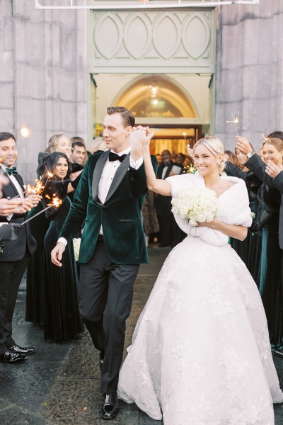 Bride and groom exit church guests clap