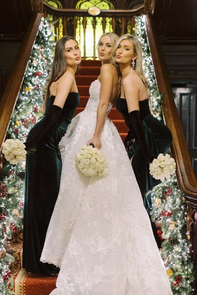 Bride and bridesmaids in satin green dresses on staircase