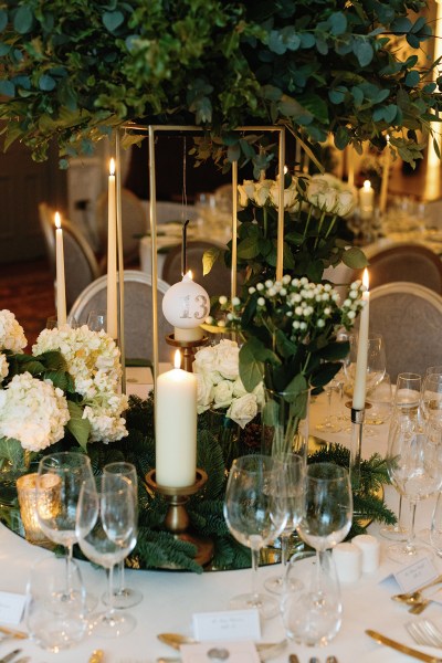 Candles lit menu and cutlery and flowers on table