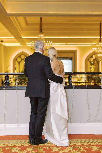 Father and daughter stand at balcony