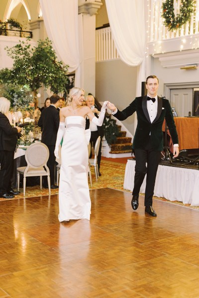 Bride and groom enter ballroom hand in hand