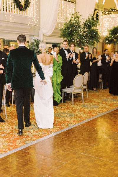 Bride and groom enter ballroom hand in hand guests clapping