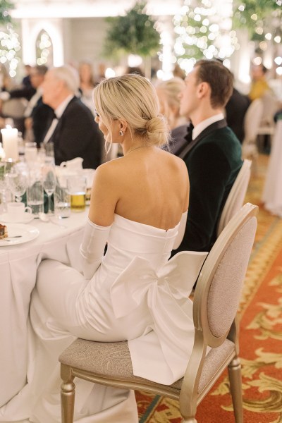 Bride sitting on chair bow detail with groom