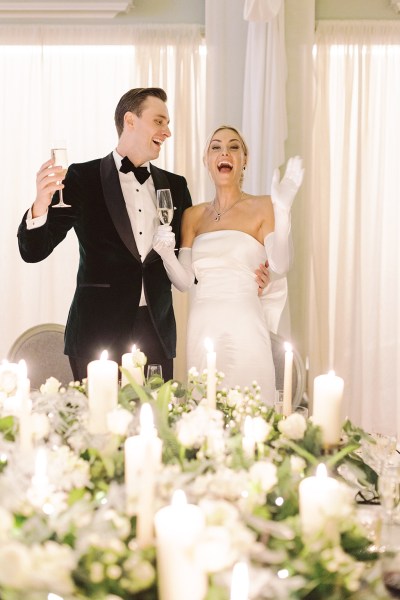 Bride and groom give speech and kiss in front of guests laughing