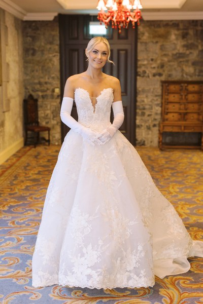 Bride stands on her own ready in bedroom