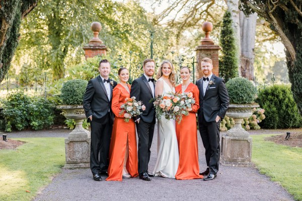 Bride bridesmaids groom and groomsmen pose exterior shot