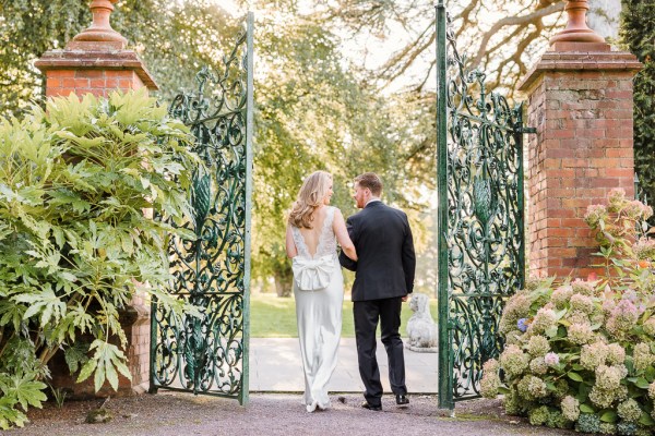 Bride and groom pass through the gate to wedding venue