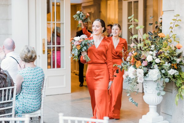 Bridesmaids in orange celebrate in dining room