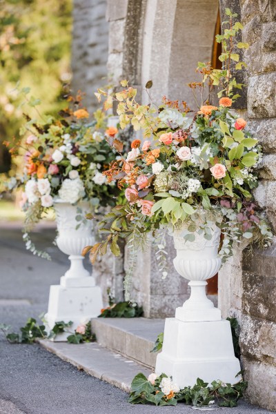 Up close orange roses and flowers at church entrance