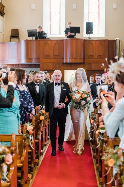 Father walks bride down the aisle guests take photos