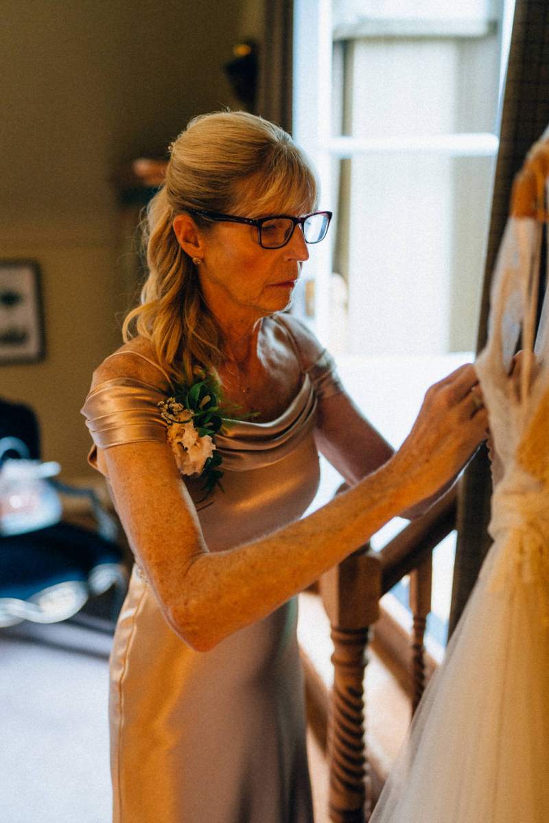 Mother helps daughter get ready back of dress