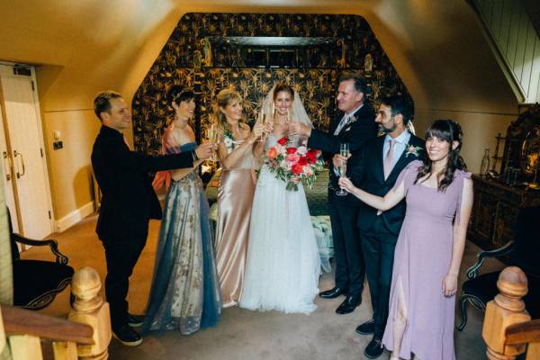 Bridesmaids bride and father cheers with a glass of champagne/prosecco