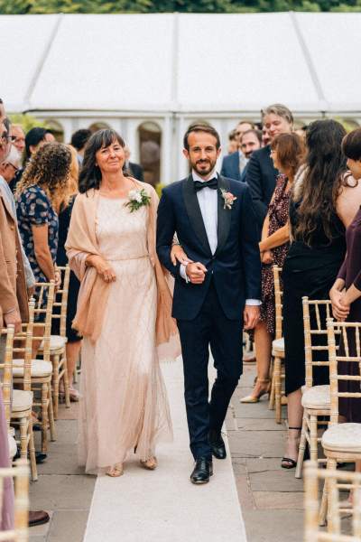 Groom and mother walk down the aisle together